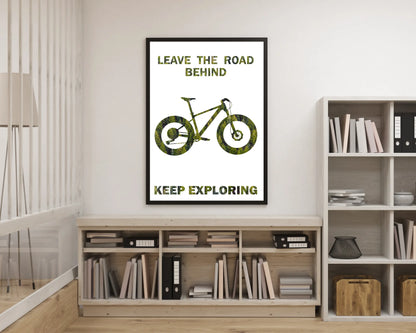 Poster with bicycle design and text 'Leave the road behind, keep exploring' on a wall in a room with bookshelves.